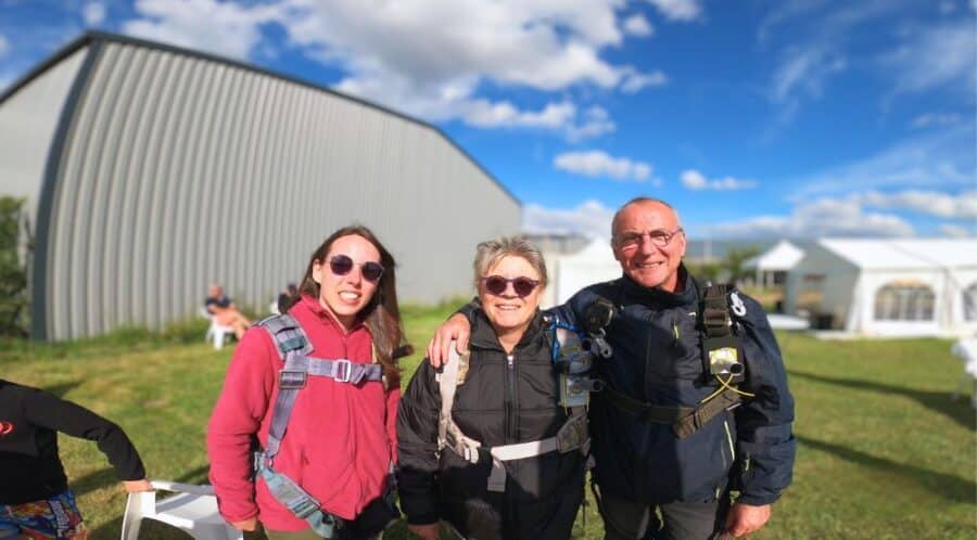 Famille et amis posant ensemble au centre de parachutisme avant le départ en avion