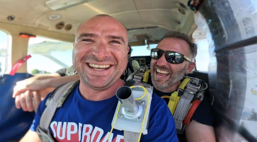 Portrait d'un passager souriant avec son moniteur à l'intérieur de la cabine avant le décollage