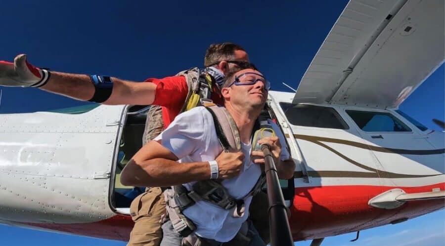 Moniteur et passager de Laval souriants dans l'avion avant un saut en parachute tandem.