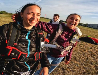 Deux amies riant en harnais après leur saut en parachute sur l'aérodrome de Tours Sorigny