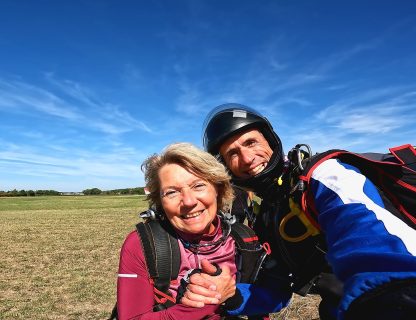 Sauteuse souriante avec son moniteur tandem après un baptême de parachute offert, à Tours Sorigny