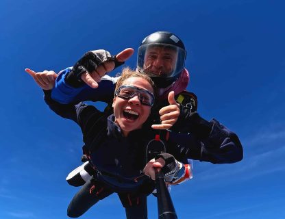 Sauteuse qui crie de joie en chute libre, attachée à son moniteur tandem