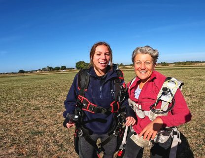 Deux sauteuses souriantes en harnais après l'atterrissage sur l'aérodrome de Tours Sorigny