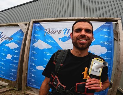 Sauteur souriant en harnais devant la bannière Tours'N Jump à l'aérodrome de Tours Sorigny