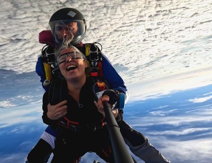 Sauteuse en éclat de rire en chute libre tandem au-dessus d'une mer de nuages
