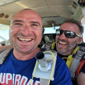 Portrait d'un passager souriant avec son moniteur à l'intérieur de la cabine avant le décollage