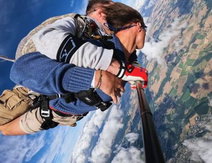 Vue au grand angle montrant le paysage et les parachutistes juste après la sortie